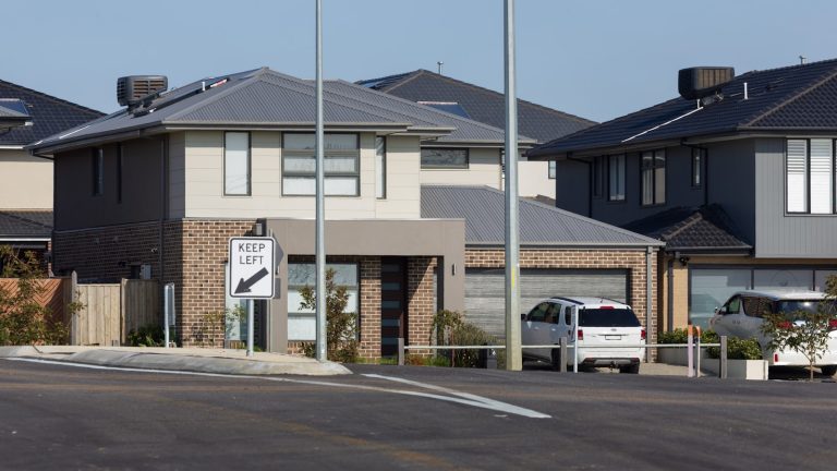 New construction homes with grey roofs and brick accents in a Texas suburb