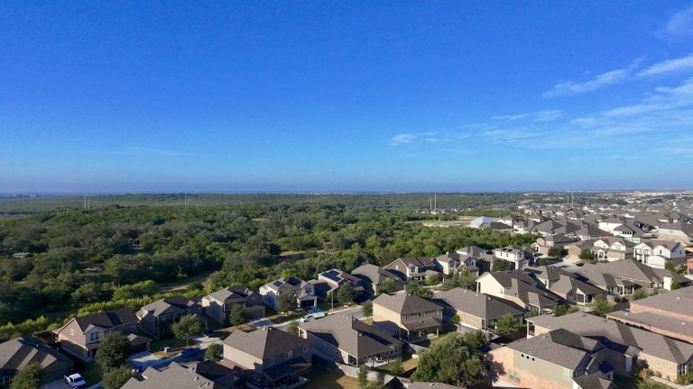 Texas suburban neighborhood with homes among green trees, illustrating homeowners insurance and the mortgage payment