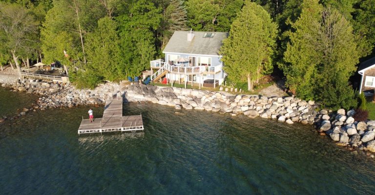 Lakeside house with a wooden dock on a sunny day, the kind of Texas lake house second-home loans finance