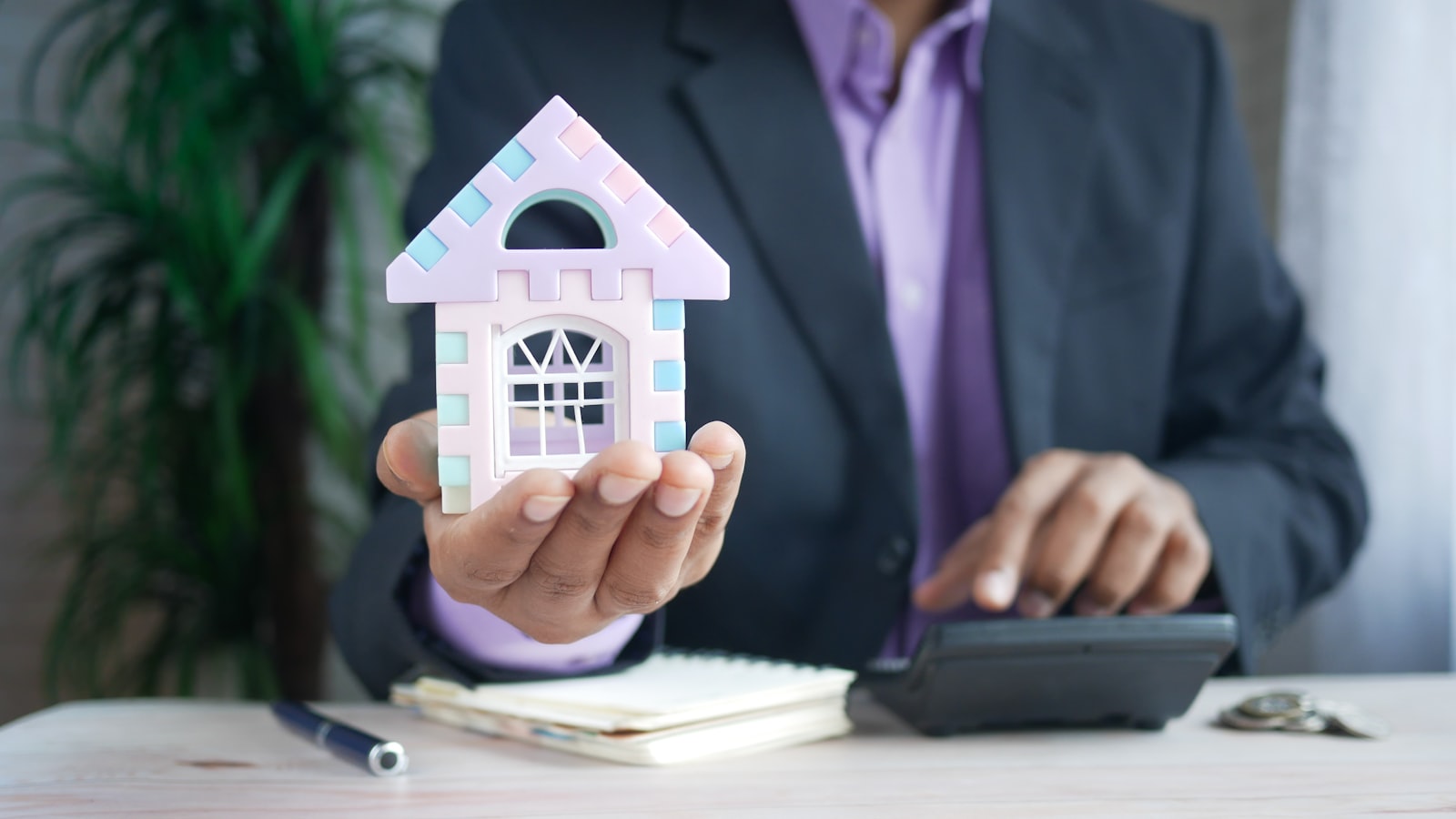 Buyer calculating a down payment in Texas with a model house and calculator