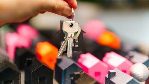 Hand passing house keys, representing a mortgage assumption transfer in Texas